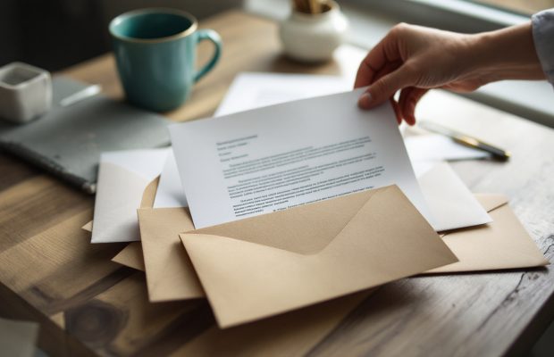 Courriers administratifs ouverts sur une table de cuisine